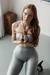 Girl in leggings tied up with hands in front struggling